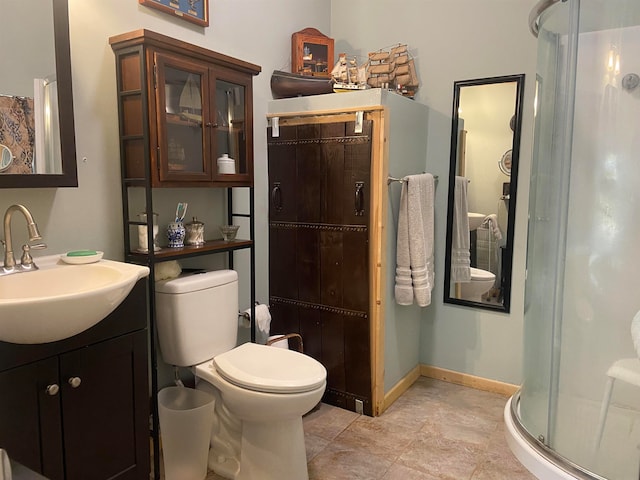 bathroom with tile patterned floors, toilet, vanity, and a shower with shower door