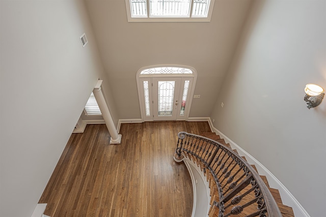 foyer entrance featuring hardwood / wood-style flooring and a towering ceiling