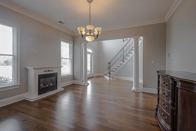 foyer entrance featuring a notable chandelier, ornate columns, ornamental molding, and wood-type flooring