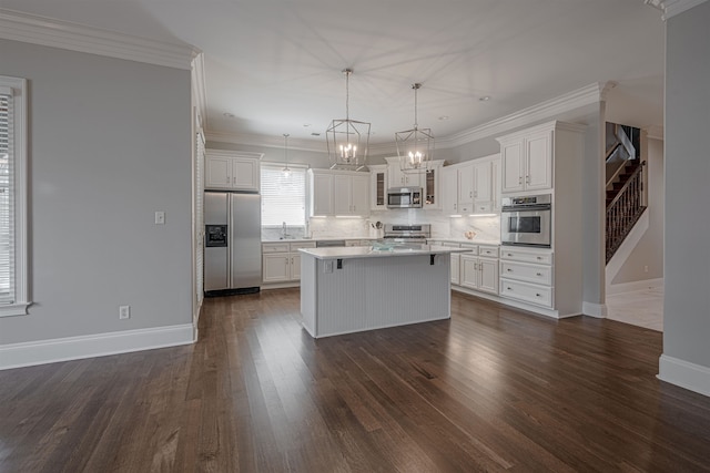 kitchen with appliances with stainless steel finishes, sink, white cabinets, a kitchen island, and dark wood-type flooring