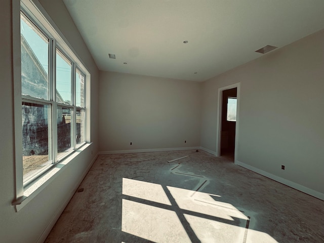 spare room with visible vents, baseboards, and a wealth of natural light