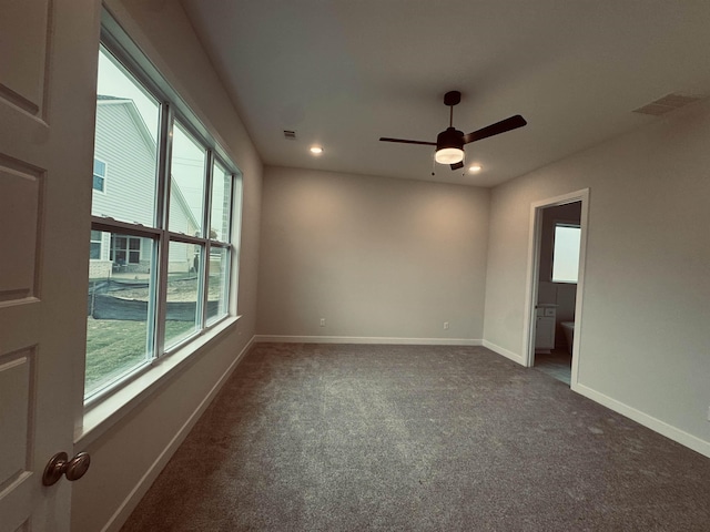 spare room with recessed lighting, dark carpet, visible vents, and baseboards