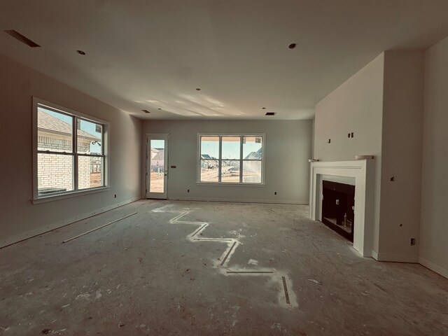 unfurnished living room with a fireplace and baseboards