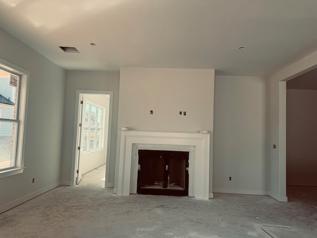 unfurnished living room featuring a healthy amount of sunlight, a fireplace, and baseboards