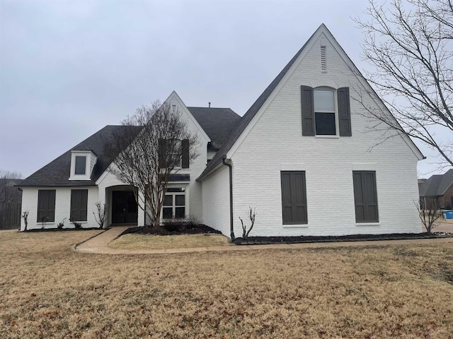 view of front of home with brick siding and a front yard