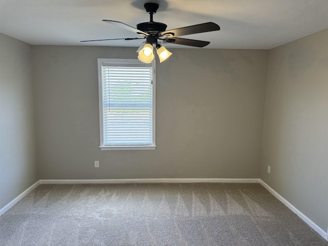 carpeted spare room with ceiling fan and baseboards