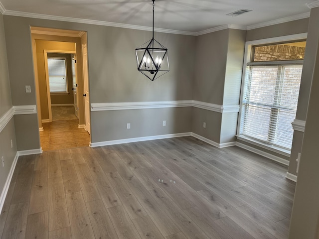 unfurnished dining area with baseboards, light wood finished floors, visible vents, and crown molding