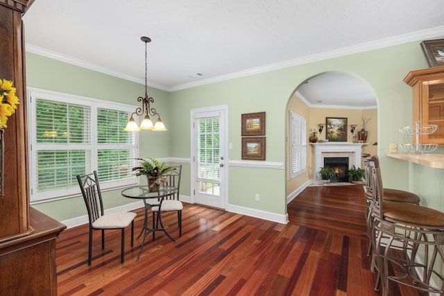 dining room featuring baseboards, ornamental molding, dark wood-type flooring, and a fireplace with flush hearth