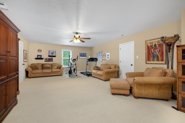 carpeted living area with a textured ceiling, ceiling fan, and visible vents