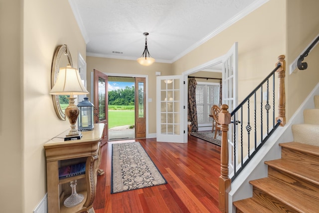 entryway featuring french doors, crown molding, dark wood-type flooring, and a textured ceiling