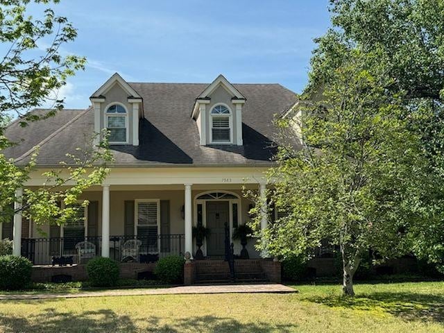 view of front of property with a front yard and a porch