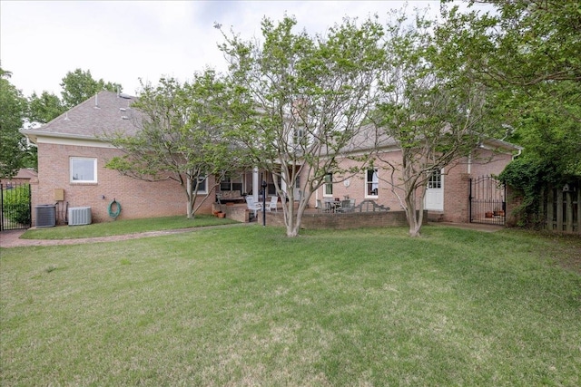 rear view of house with a lawn and cooling unit