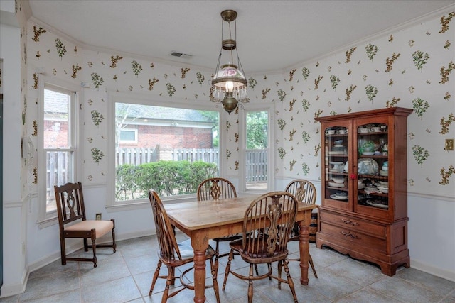 dining area with crown molding and light tile patterned floors