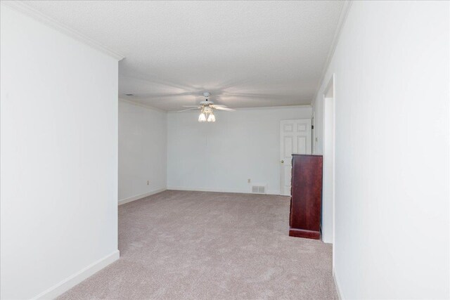 carpeted empty room featuring a textured ceiling, ceiling fan, and ornamental molding