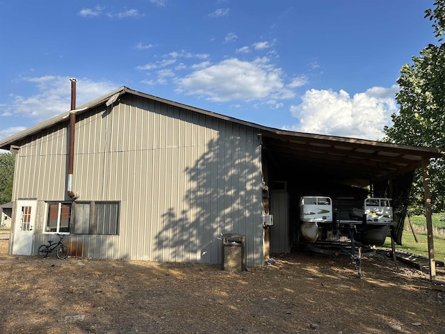 view of home's exterior featuring an outbuilding, a carport, and an outdoor structure