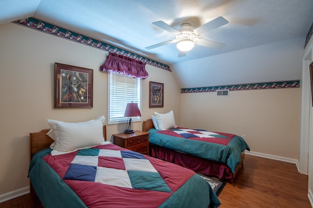 bedroom with ceiling fan, a textured ceiling, lofted ceiling, and hardwood / wood-style floors