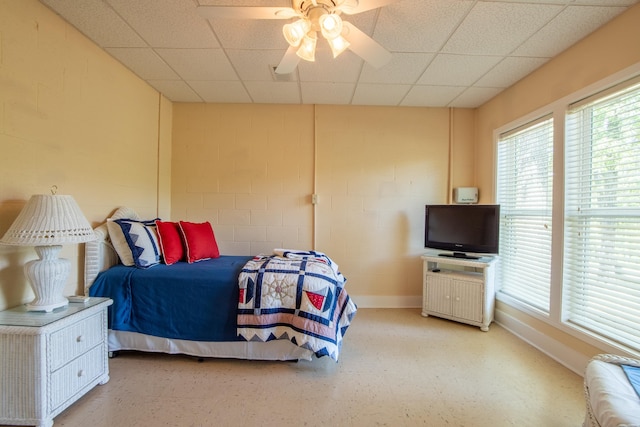 bedroom with ceiling fan and a paneled ceiling