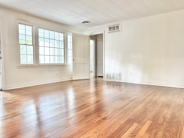 spare room with ornamental molding and hardwood / wood-style flooring