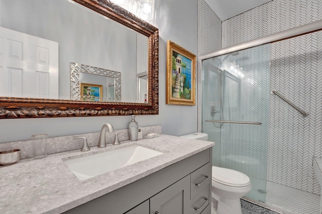 bathroom with a shower with door, vanity, and toilet