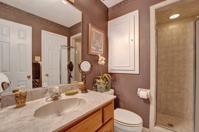 bathroom featuring an enclosed shower, vanity, and toilet