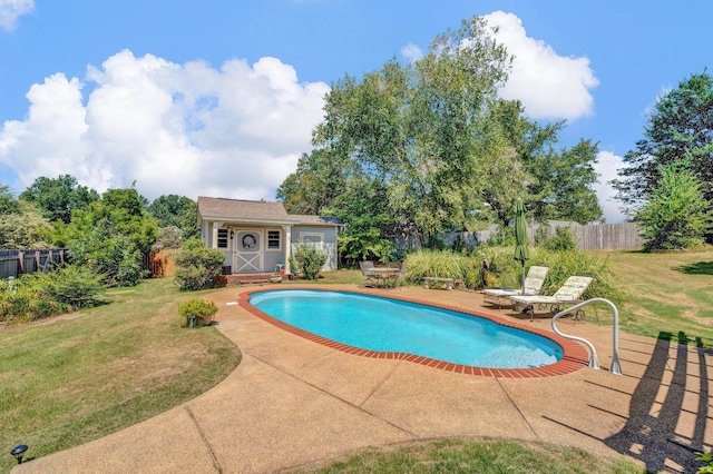 view of pool featuring a patio area, an outdoor structure, and a lawn