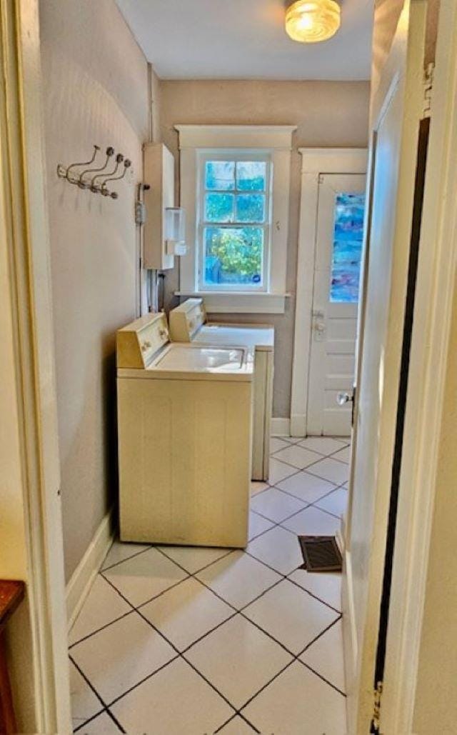 bathroom with washer and clothes dryer, water heater, and tile patterned floors