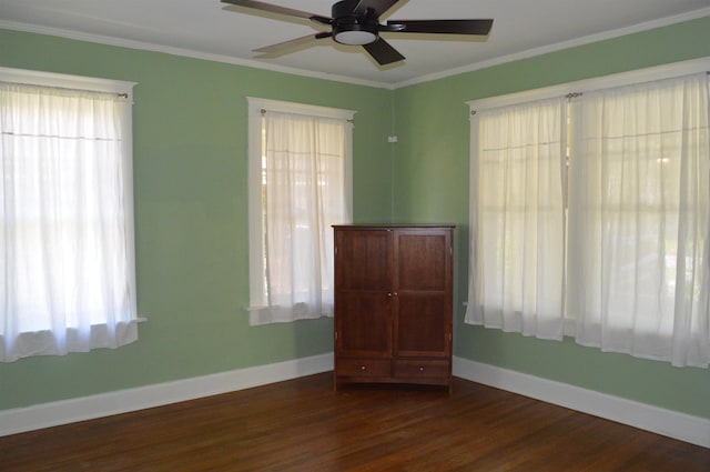 spare room featuring ceiling fan, dark hardwood / wood-style floors, crown molding, and plenty of natural light