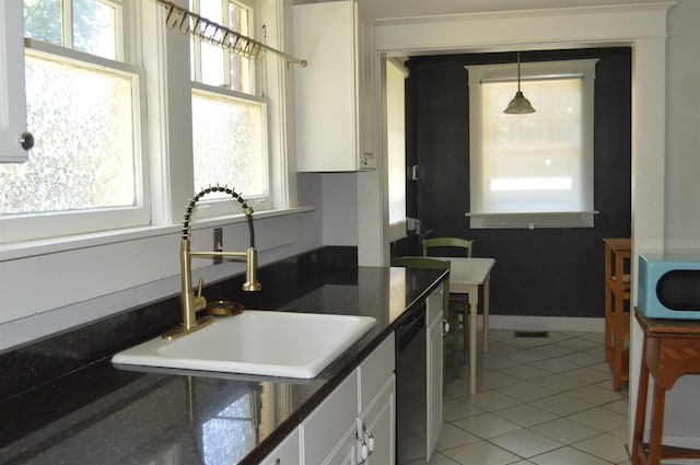 kitchen with white cabinetry, sink, hanging light fixtures, and light tile patterned flooring