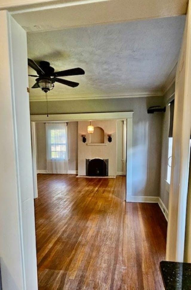 unfurnished living room featuring ceiling fan, a textured ceiling, and wood-type flooring