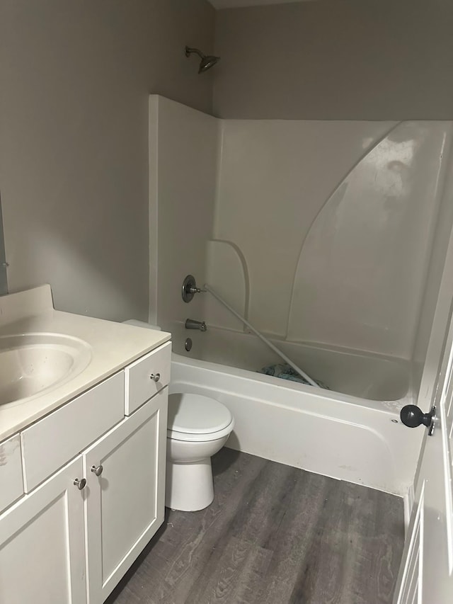 full bathroom featuring toilet, hardwood / wood-style flooring, shower / washtub combination, and vanity