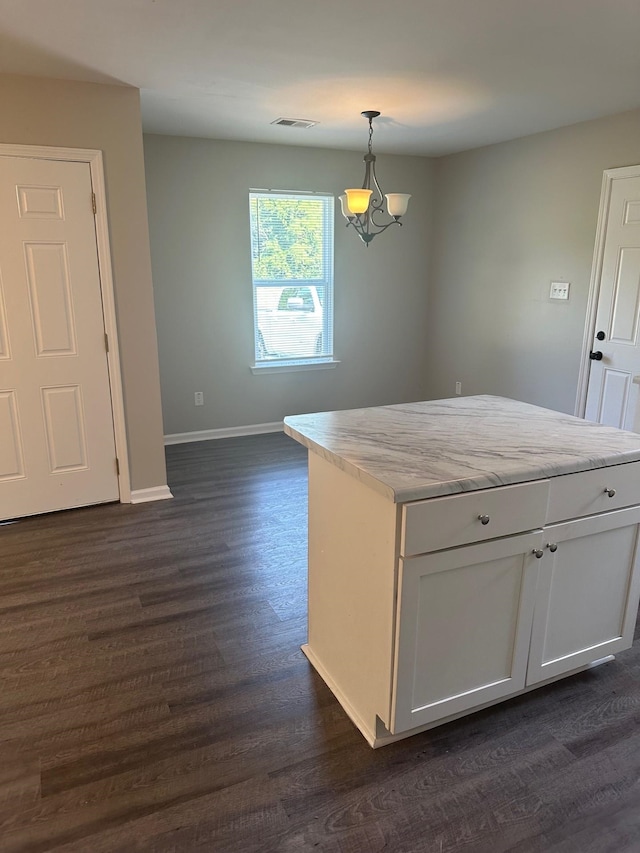 kitchen featuring decorative light fixtures, white cabinetry, a chandelier, dark hardwood / wood-style floors, and light stone countertops