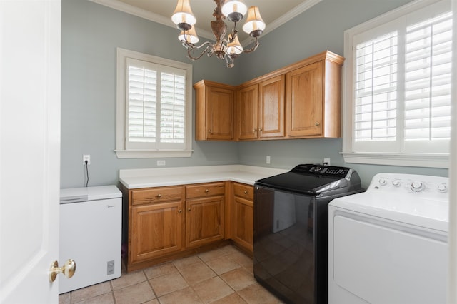 laundry area featuring light tile patterned floors, washer and clothes dryer, ornamental molding, and cabinets