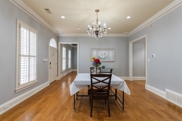 dining room with plenty of natural light, light hardwood / wood-style flooring, and an inviting chandelier