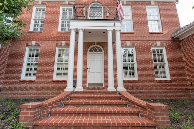 view of exterior entry featuring a balcony