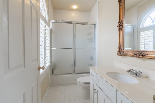 full bathroom featuring shower / bath combination with glass door, toilet, vanity, and tile patterned floors