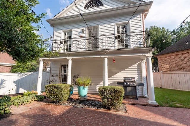 view of front facade with a balcony and covered porch