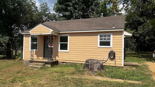 bungalow-style home with a shingled roof, crawl space, and a front yard