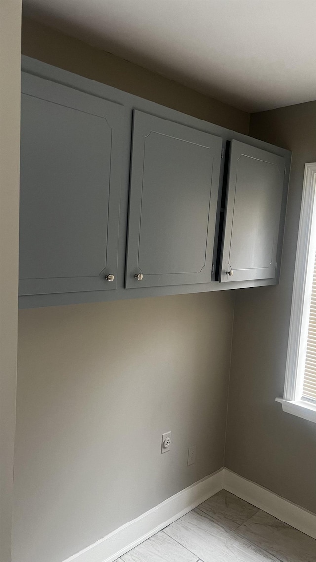 washroom with baseboards and hookup for an electric dryer