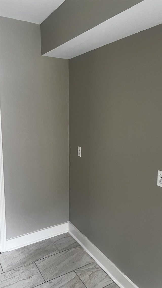 spare room featuring baseboards and marble finish floor
