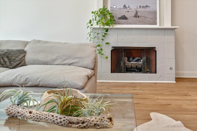 living room with light hardwood / wood-style flooring and a tile fireplace