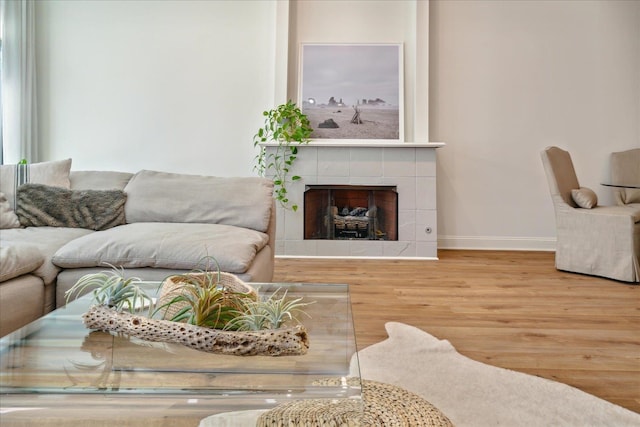 living room with light hardwood / wood-style flooring and a tiled fireplace