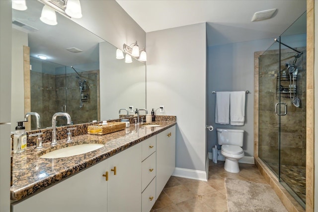 bathroom with tile patterned floors, toilet, vanity, and a shower with shower door