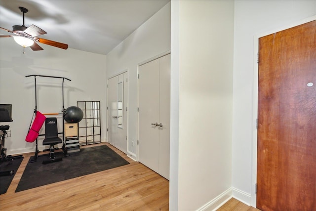 exercise room with ceiling fan and wood-type flooring