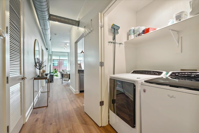 laundry area featuring light hardwood / wood-style floors and washing machine and dryer