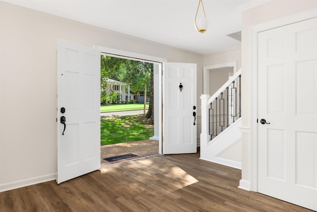 entrance foyer featuring ornamental molding and dark hardwood / wood-style flooring