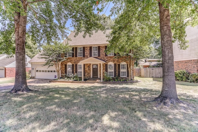 colonial inspired home with a front yard and a garage