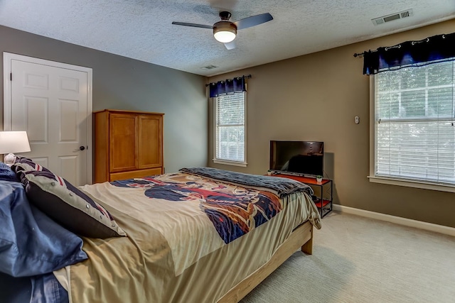 carpeted bedroom with a textured ceiling and ceiling fan