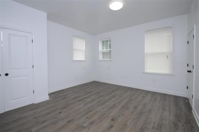 spare room with plenty of natural light and dark hardwood / wood-style floors