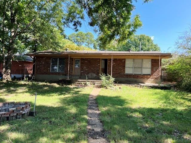 rear view of house with brick siding and a lawn