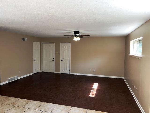 empty room featuring carpet, visible vents, and tile patterned floors